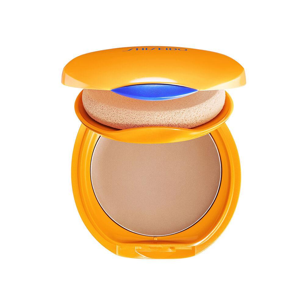 Cipria compatta Shiseido Sun con confezione gialla dorata, prodotto aperto che mostra polvere beige e spugnino