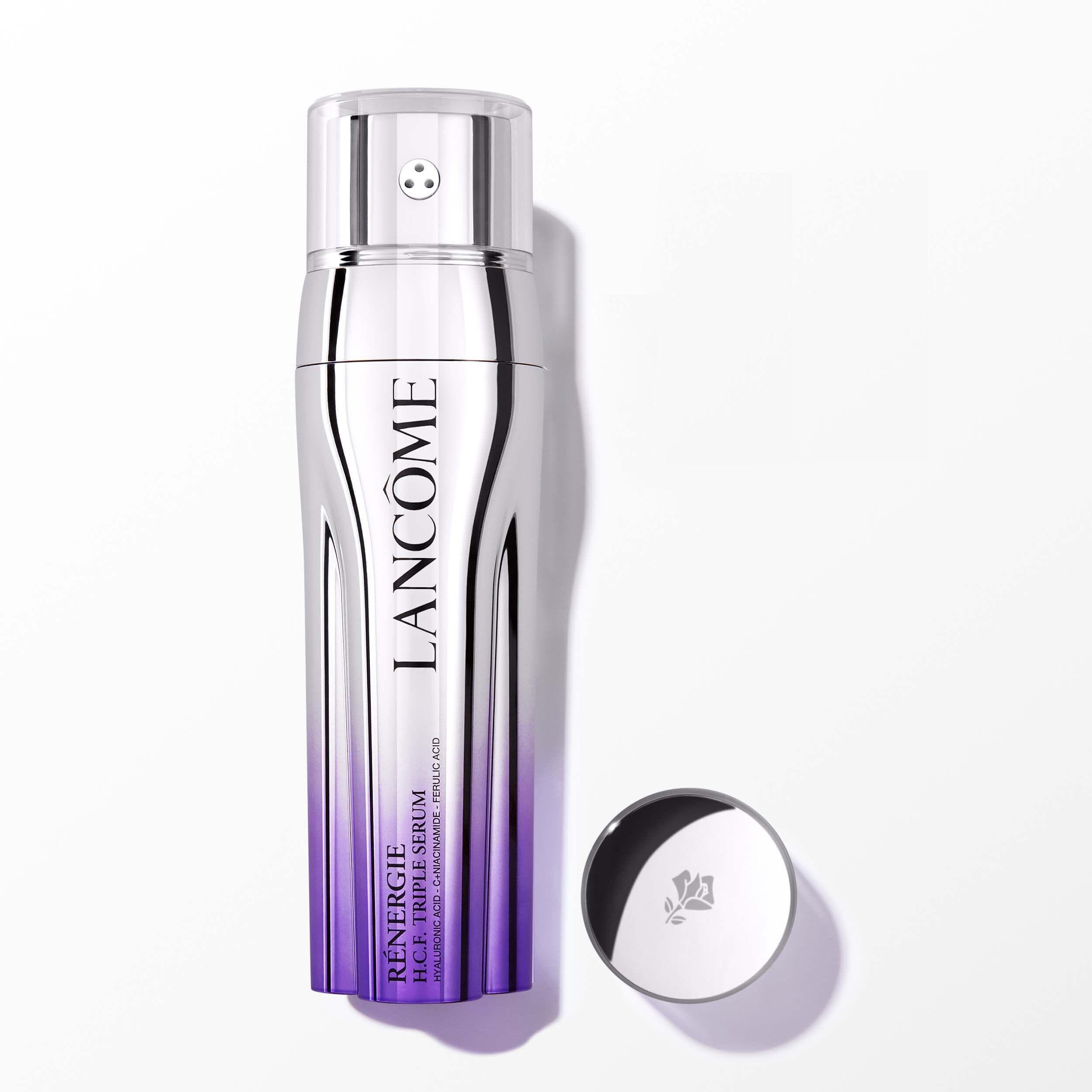 Bottiglia spray trasparente con sfumatura bianco-viola, scritta LANCOME e tappo rotondo con logo