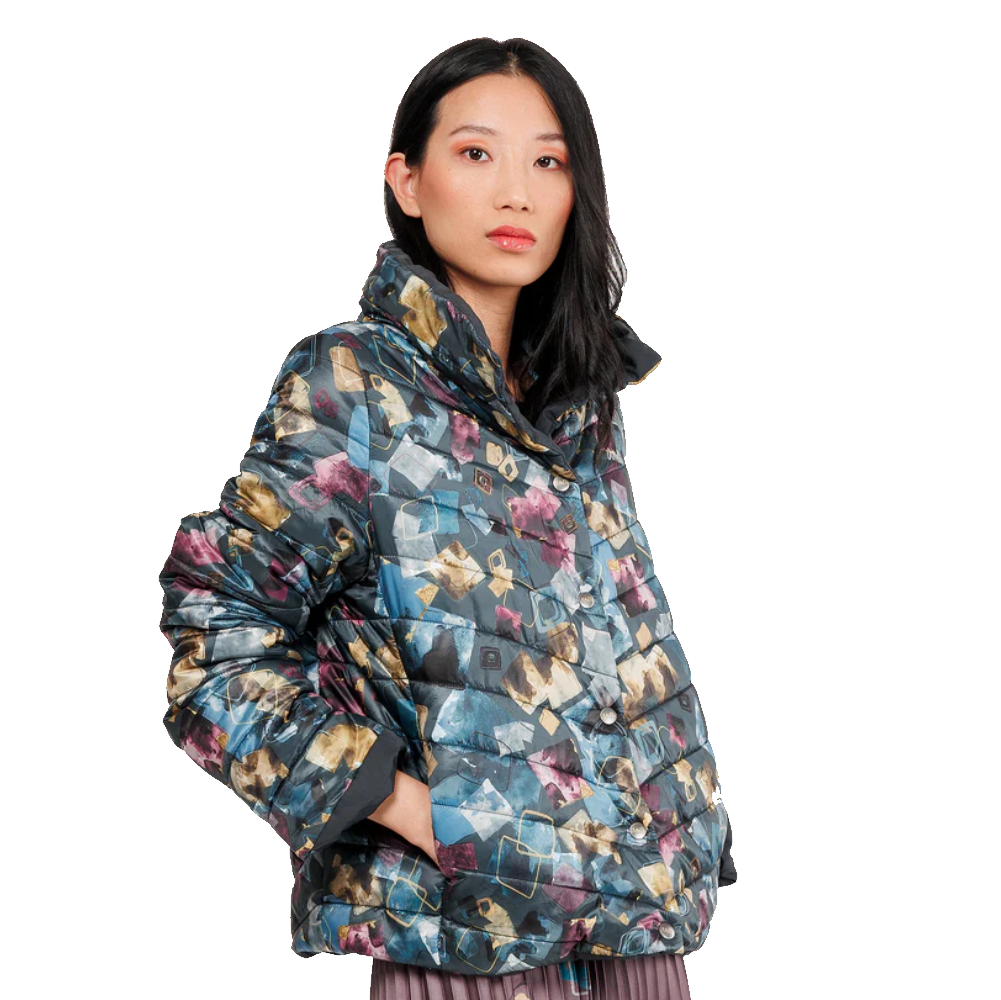 Donna che indossa giacca piumino multicolore con stampa astratta blu, verde e rosa, vista frontale, isolata su sfondo bianco